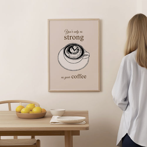 Coffee Poster – As Strong as Your Coffee – framed and displayed on a wall